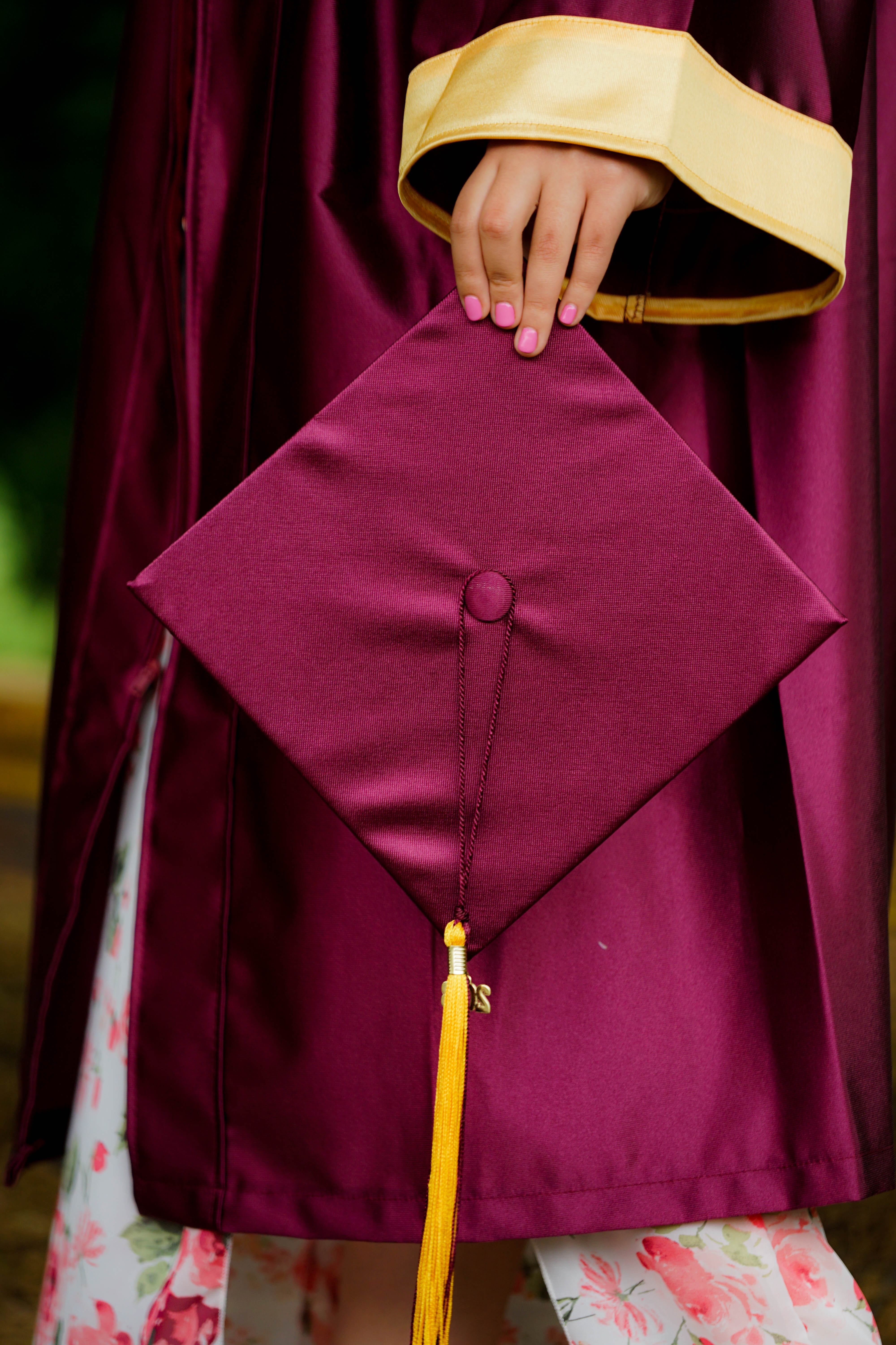 Foto de una mano sujetando un birrete de graduación